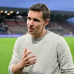 David Hubert in een grijze trui tijdens een interview naast het veld in Oostende.