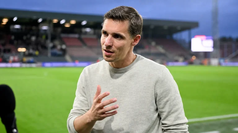 David Hubert in een grijze trui tijdens een interview naast het veld in Oostende.