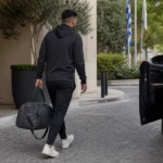 Een niet-identificeerbare voetballer verlaat met bagage een hotel in Griekenland.