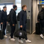 Spelers en staf van KAA Gent stappen met reistassen aan boord van een vliegtuig.