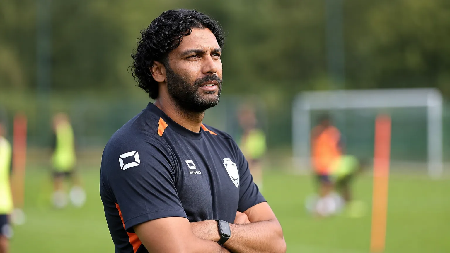 Marvin Compper volgt aandachtig een oefening op een trainingsveld.