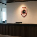 Een rustige ontvangstruimte van Royal Antwerp FC met een clublogo aan de wand.