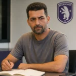 Flavien Le Postollec in een vergaderruimte met een subtiel Beerschot-embleem op de wand.