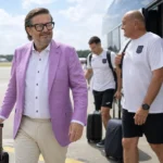 Marc Coucke stapt op het tarmac naast de teamcoach van RSC Anderlecht.