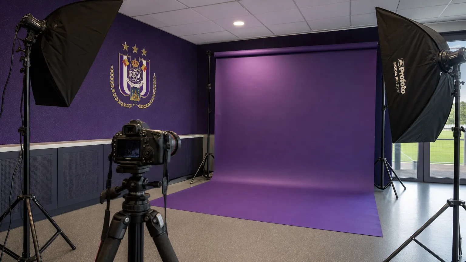 Voorbereiding van een U23-fotoshoot bij RSC Anderlecht met paarse clubachtergrond.