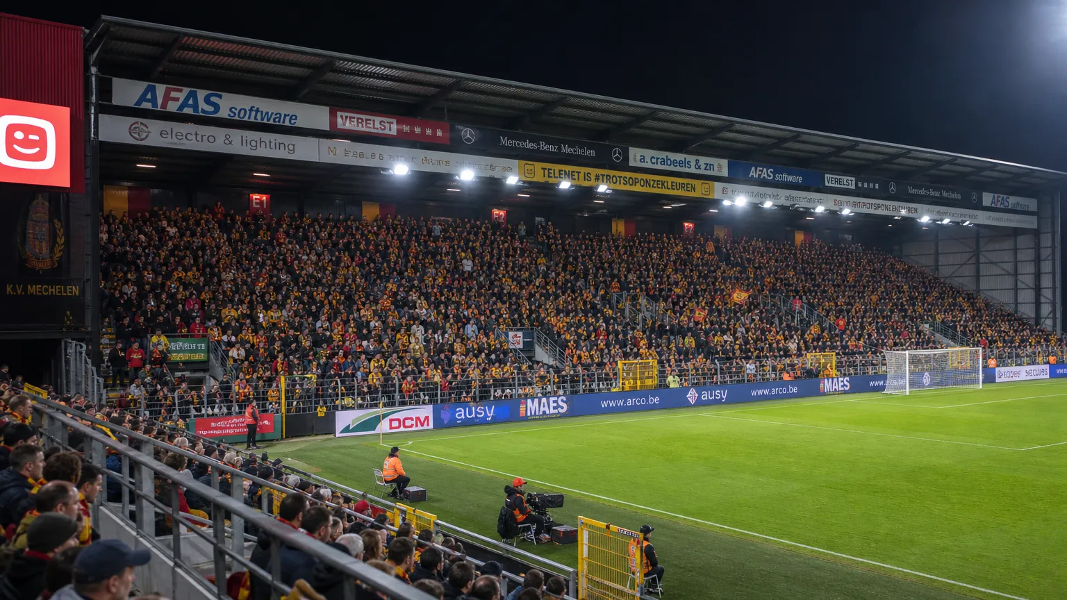 Breed beeld van een wedstrijdavond in het stadion van KV Mechelen met supporters op de tribunes.