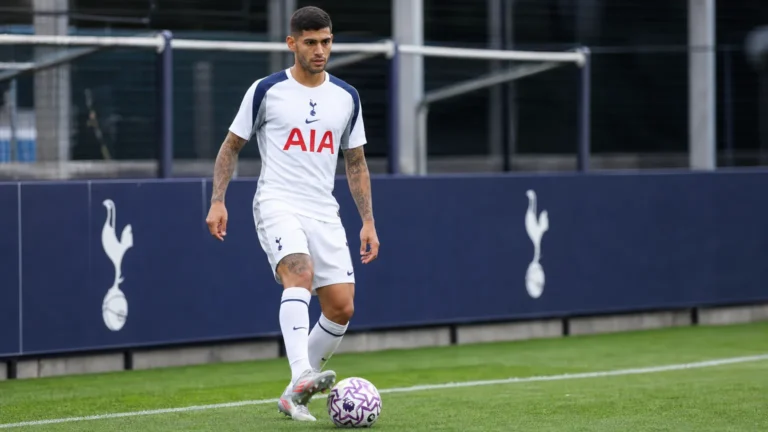 Cristian Romero in het tenue van Tottenham Hotspur aan de rand van een voetbalveld.