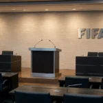Een leeg officieel FIFA-podium met een spreekgestoelte in een vergaderzaal.