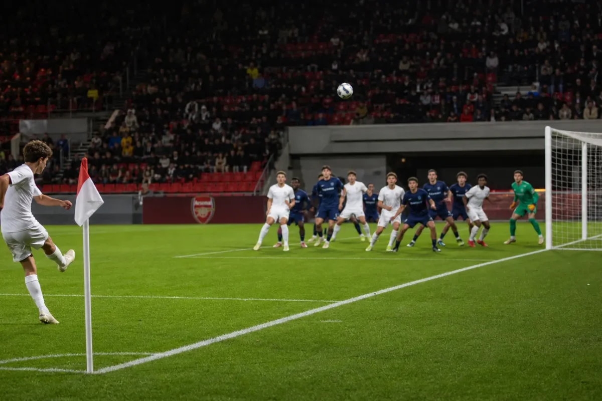 Een hoekschop wordt in een voetbalstadion richting het strafschopgebied getrapt.