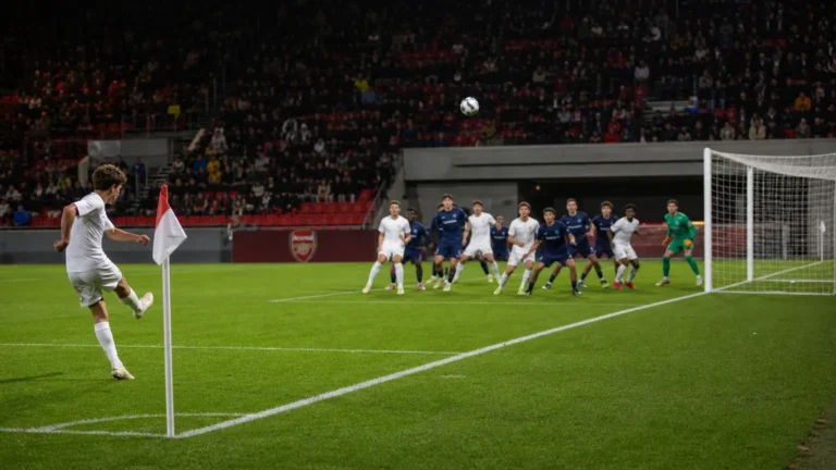 Een hoekschop wordt in een voetbalstadion richting het strafschopgebied getrapt.