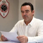Een clubvertegenwoordiger bekijkt documenten in een vergaderruimte van Royal Antwerp FC.