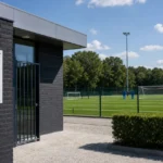 Een trainingsveld aan de jeugdacademie van KRC Genk met het clubanker aan de ingang.