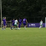Brede wedstrijdscène van RSCA Futures in paarse en witte tenues tijdens een oefenmatch.