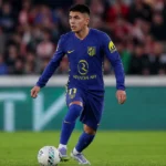Thiago Almada in een donkerblauw wedstrijdshirt tijdens een actie op het veld.