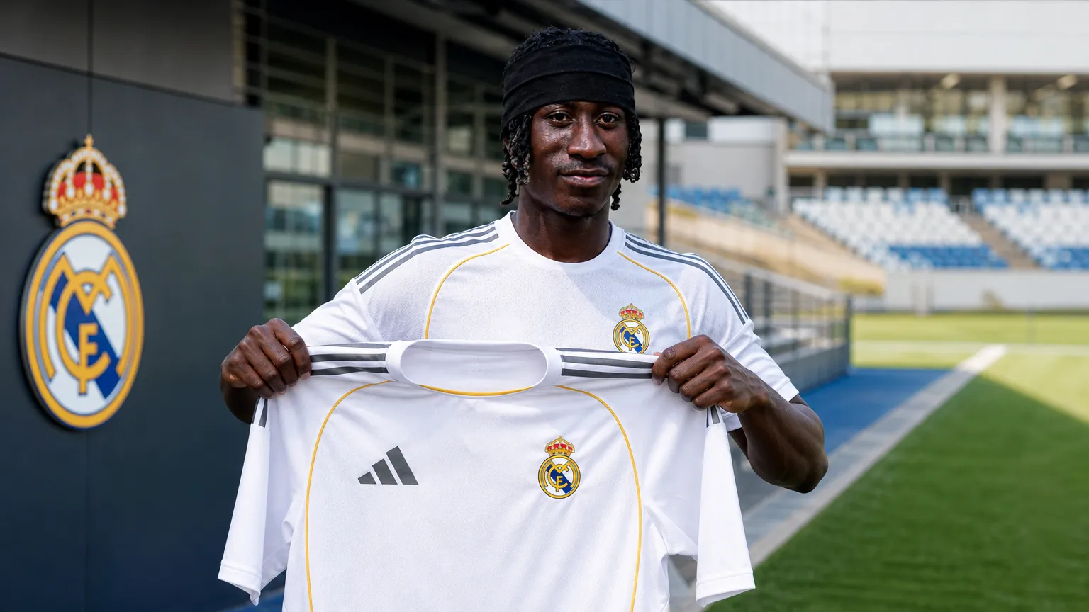 Yan Diomande toont een Real Madrid-shirt tijdens een officiële clubpresentatie.