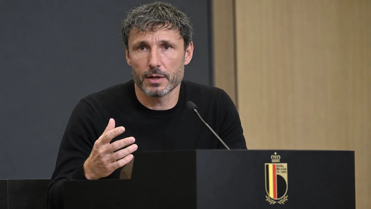 Mark van Bommel spreekt aan een lessenaar tijdens een persconferentie van de Belgische voetbalbond.