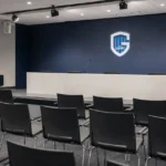 Voorbereide persruimte van KRC Genk met een podium en persstoelen.