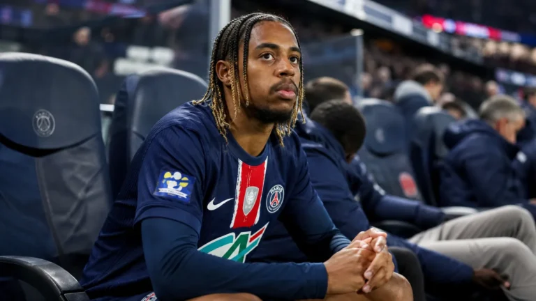 Bradley Barcola zit in tenue op de bank naast het voetbalveld.