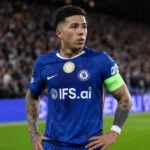 Enzo Fernández in blauw Chelsea-tenue op het veld voor een wedstrijd.