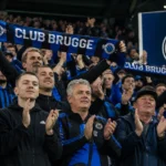 Supporters van Club Brugge applaudisseren in een volgelopen thuisvak.