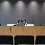 Een neutrale persruimte met een lessenaar en microfoons voor een voetbalpersbabbel.