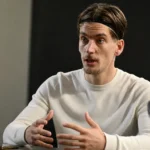 Dennis Praet tijdens een rustig interview in een neutrale binnenruimte.