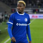 Hyllarion Goore van KAA Gent staat aan de rand van het veld in blauw wedstrijdshirt.