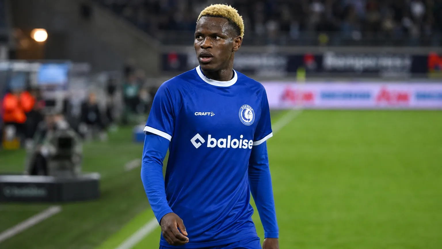 Hyllarion Goore van KAA Gent staat aan de rand van het veld in blauw wedstrijdshirt.