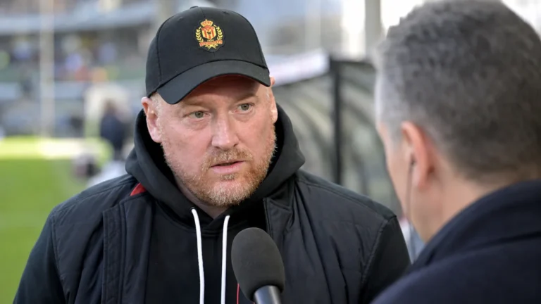 Fred Vanderbiest spreekt met een journalist aan de rand van een stadion.