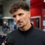 Thomas Meunier spreekt met een journalist in de mixed zone van een stadion.