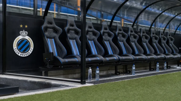 Lege zitplaatsen in de dug-out van Club Brugge aan de rand van het veld.