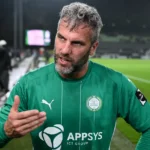 Ralf Seuntjens in groen voetbalshirt tijdens een gesprek naast het veld.