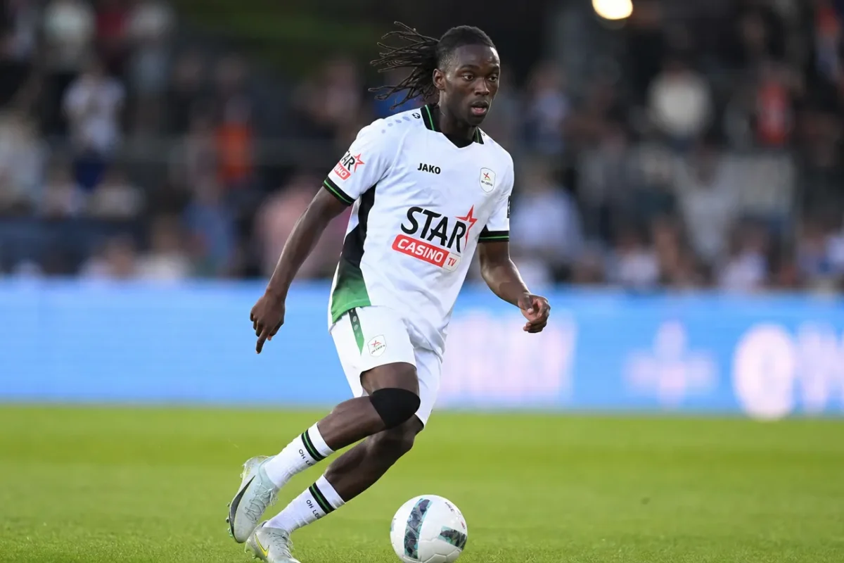 Davis Opoku in wit wedstrijdtenue tijdens een voetbalmoment op het veld.