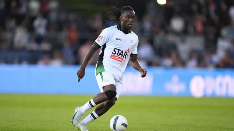 Davis Opoku in wit wedstrijdtenue tijdens een voetbalmoment op het veld.