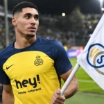Anan Khalaili staat in Union-tenue langs de zijlijn van een voetbalveld.