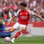 Een Arsenal-speler in rood-wit tenue in actie tijdens een wedstrijd.