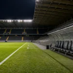 Een leeg verlicht voetbalveld kort na een wedstrijd.