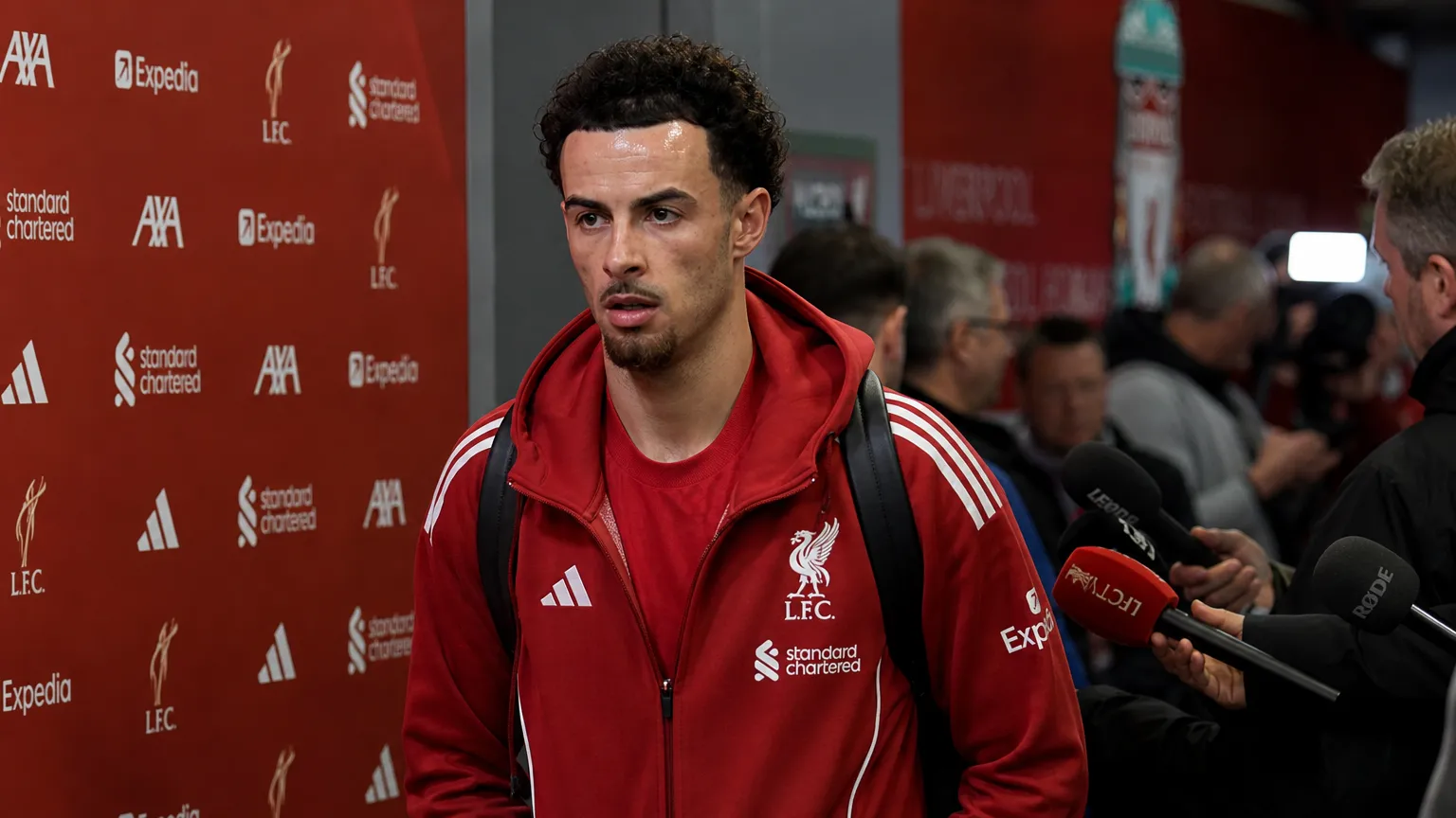 De mixed zone bij Anfield met Liverpool-signalisatie en journalisten.