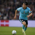 Ayase Ueda in een lichtblauw Feyenoord-shirt tijdens een voetbalactie op het veld.