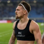 Adriano Bertaccini in een zwarte GPS-vest naast het voetbalveld.