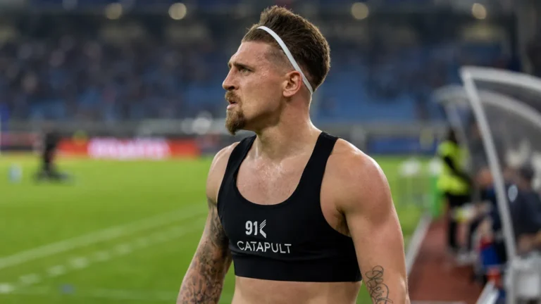 Adriano Bertaccini in een zwarte GPS-vest naast het voetbalveld.