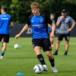 Een trainingsmoment aan het complex van Club Brugge met spelers en staf in de achtergrond.