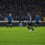 Club Brugge-spelers in blauw-zwarte shirts houden balbezit tijdens een thuiswedstrijd.