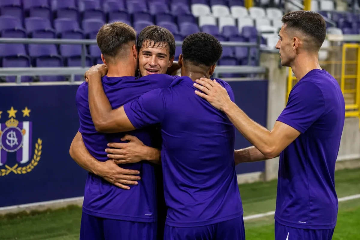Een groep Anderlecht-spelers viert samen op het veld na de wedstrijd.