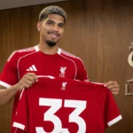 Ronald Araújo houdt tijdens zijn officiële voorstelling een Liverpool-shirt met rugnummer 33 vast.