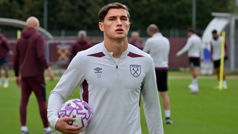 Een voetbaltraining op het complex van West Ham United met spelers en staf op de achtergrond.