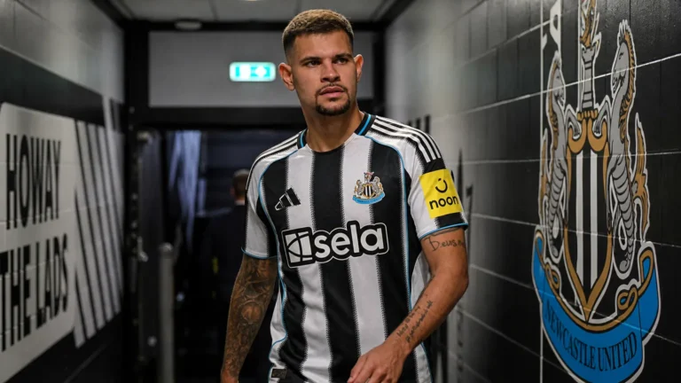 Voetbalcontext van Newcastle United in een spelerstunnel met clubkleuren op de achtergrond.