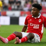 Carlos Mejia van Antwerp zit op het veld na zijn blessure.