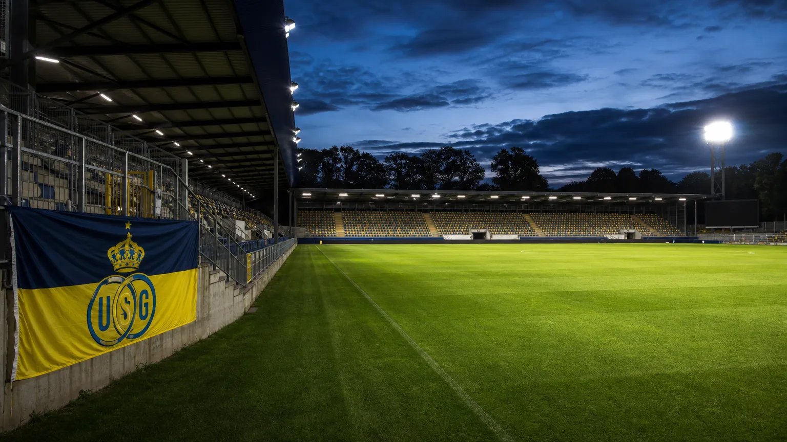 Een Union-vlag aan de rand van een verlicht Europees voetbalstadion.