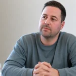 Frank Boeckx tijdens een rustig indoorinterview in een grijze trui.